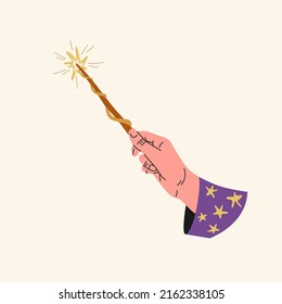 The hand of a person holds a magic wand. The hand of a fairy-tale character.
