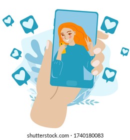 Hand with phone with faces of girl. Lovers communicate by video call.