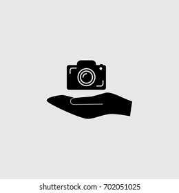 Hand and photocamera vector icon