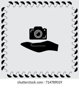 Hand and photocamera vector icon