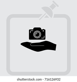 Hand and photocamera vector icon