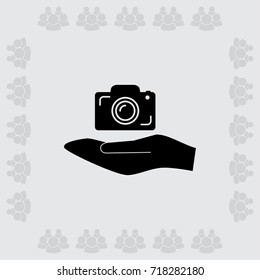 Hand and photocamera vector icon