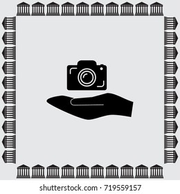 Hand and photocamera vector icon