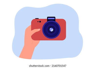 Hand of photographer holding red camera. Person buying camera or taking photo flat vector illustration. Photography, hobby, memories concept for banner, website design or landing web page