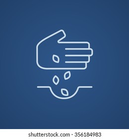 Hand planting seeds in the ground line icon for web, mobile and infographics. Vector light blue icon isolated on blue background.