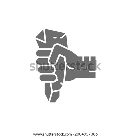 Hand with prehistoric stone, ancient rock knife gray icon.