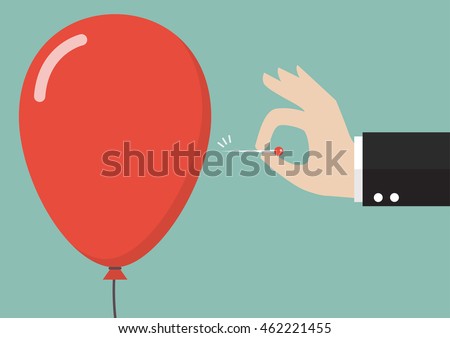 Hand pushing needle to pop the balloon. Business concept