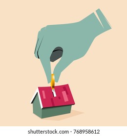 Hand putting coin in house piggy bank
