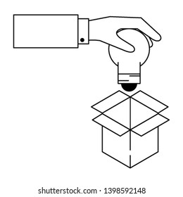hand putting light bulb into box in black and white