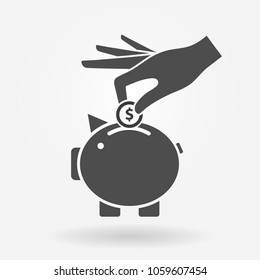 Hand putting money coin into piggy bank. Savings and banking icon concept