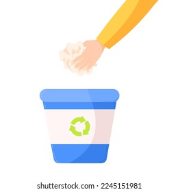 a hand putting a paper litter in a blue recycling trash can. the concept of a sorting wastes