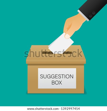 Hand putting paper in the suggestion box.
