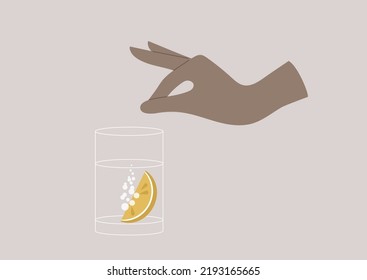 Hand putting a slice of lemon into a glass of sparkling water, summer refreshments