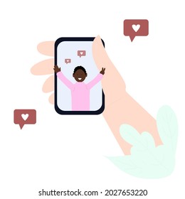 Hand with a smartphone. On the screen, a smiling African American in a pink sweater.