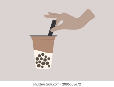 Hand stirring tapioca boba tea with a straw