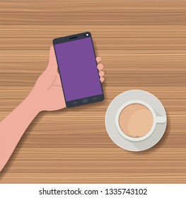 hand using smartphone with coffee cup in the table