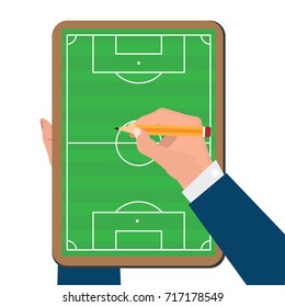 Hand writing a soccer game strategy on football board.
