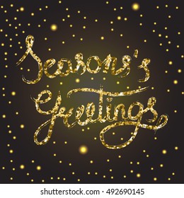 Hand written golden glitter Seasons greetings phrase. Black background with shining in the middle and bokeh effect