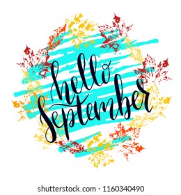 Hand written lettering message hello september.  Autumn welcome quote on color leaves stamp background. Modern colors, yellow, red, cyan. Hello September design for cards, banners, posters.