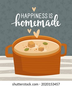 Hand-drawn card, print. A saucepan with a hot aromatic first course on the table. Cream soup with croutons and spices. Handwritten lettering "happiness is homemade". Homemade food, delicious meals.
