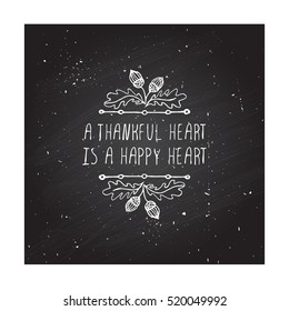 Handdrawn thanksgiving label with acorns and text on chalkboard background. A thankful heart is a happy heart.