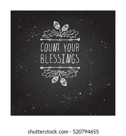 Handdrawn thanksgiving label with acorns and text on chalkboard background. Count your blessings.