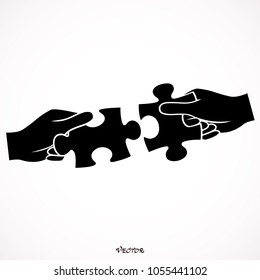 Hands assembling jigsaw puzzle pieces together