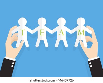 Hands Of Businessman Or Manager Holding People Cut Out Of Paper With Text Team