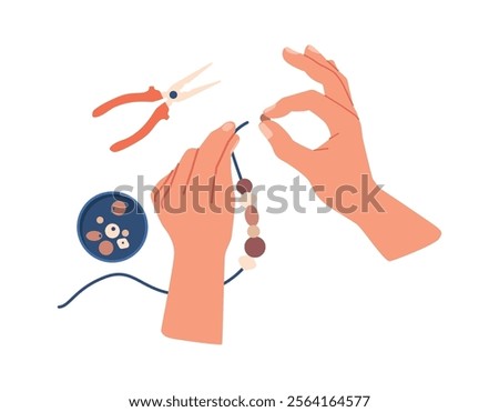 Hands creating necklace from beads