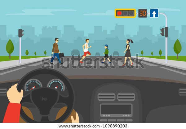 Hands driving a car on the\
street. Driver is waiting on red light while group of people\
crossing road on crosswalk with traffic lights. Flat vector\
illustration.