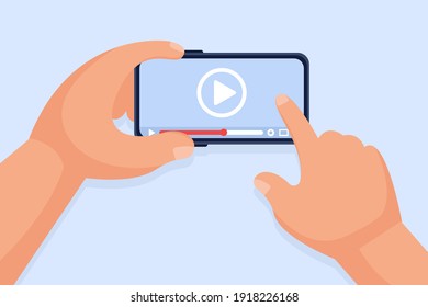 Hands hold a smartphone and touch the screen. Video player on the screen. Video content marketing concept. Online training, video conferencing and webinars, publishing information in video.