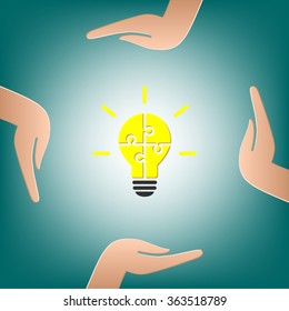 Hands holding a bright lightbulb. Bulb made of puzzle as idea and teamwork concept.