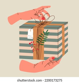 Hands holding Christmas gift in kraft paper with tag and berries. Present box in craft wrapping paper with bow and branches. Colored flat vector illustration isolated on background.