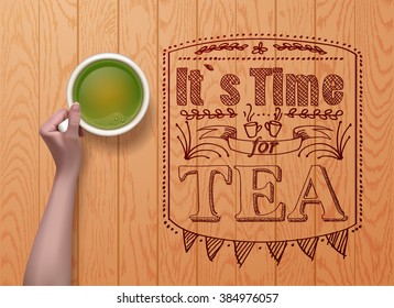 hands holding cup green tea on wooden background. it`s time for tea