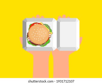 hands holding delicious burger in  cardboard box on yellow background top view