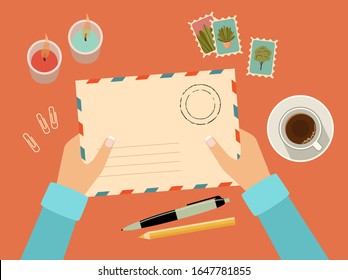 Hands holding envelope with stamps. Stationery. Top view. Sending written letter through postal service. Vector flat illustration
