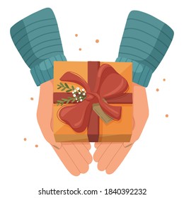 Hands holding a gift box decorated by plants and berries. Vector illustration.