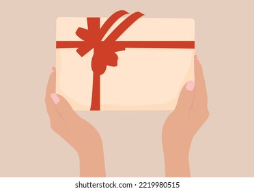 Manos sosteniendo una caja de regalo. Caja de regalo en las manos. Ilustración del vector
