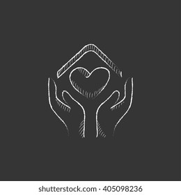Hands holding house symbol with heart shape. Drawn in chalk icon.