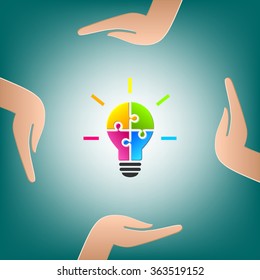 Hands holding a lightbulb. Bulb made of colourful puzzle pieces as idea and diversity concept.