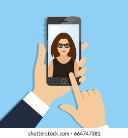 Hands holding phone with female portrait on screen