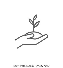 Hands holding seedling in soil line icon.