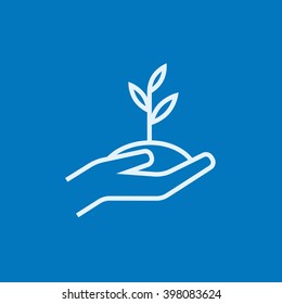 Hands holding seedling in soil line icon.