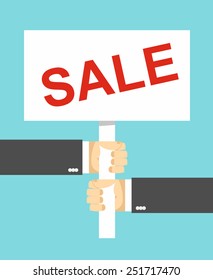 hands holding a sign. Sale text.  