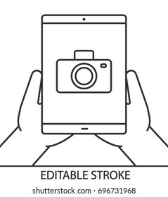 Hands holding tablet computer linear icon. Thin line illustration. Tablet computer with camera. Contour symbol. Vector isolated outline drawing. Editable stroke
