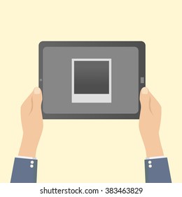 hands holding a tablet with a photo frame