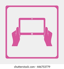 Hands holing tablet computer with blank screen.