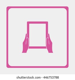 Hands holing tablet computer with blank screen.