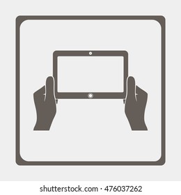 Hands holing tablet computer with blank screen.