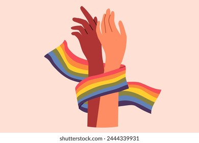 Hands of non-binary couple holding LGBT flag symbolizing love and unity between transgender and gay or lesbian. Pride month concept to promote the idea of tolerance towards LGBT people.